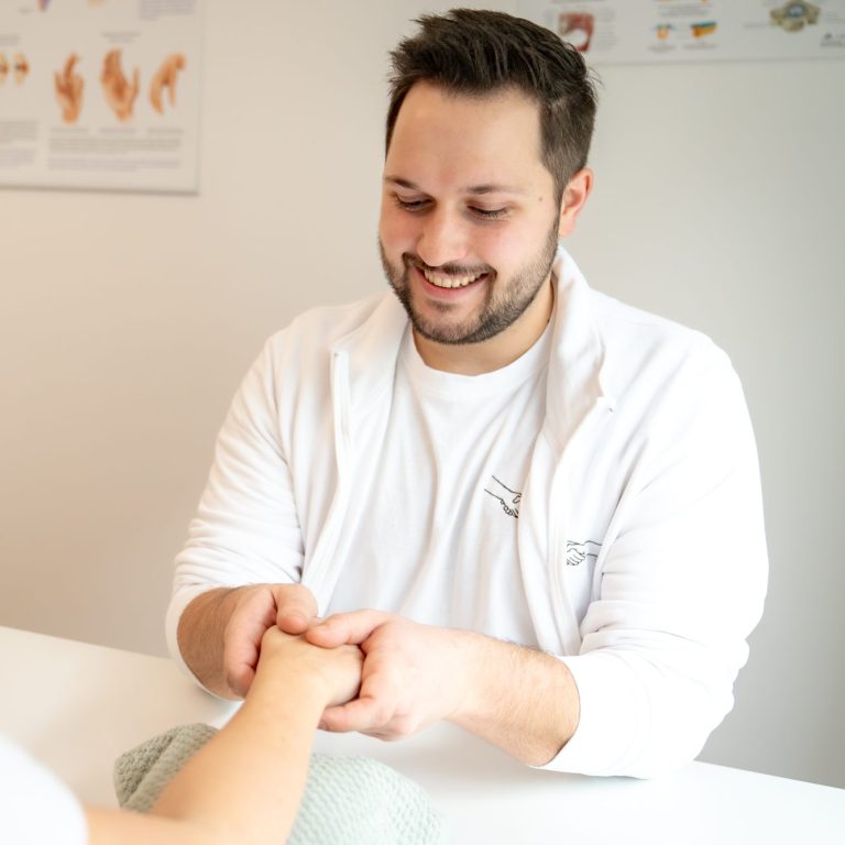 Patrik Schreiber BSc - Ergotherapeut in 1030 Wien, behandelt eine Patientin mit Schmerzen in der Handtherapie auf Krankenkassa