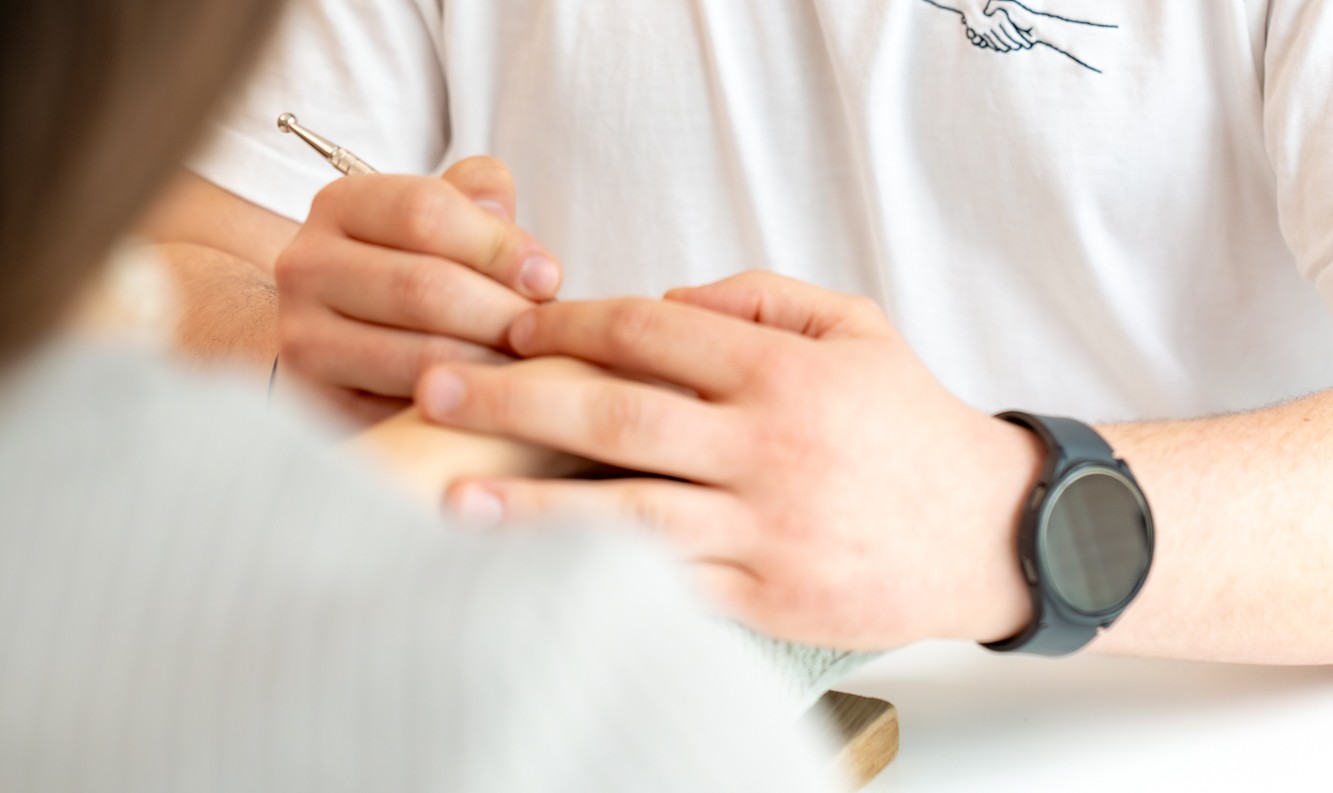 Felix Wernhart BSc, Kassenvertrags-Ergotherapeut in Wien 1030, führt Handtherapie mit einer Patientin durch, Fokus auf Handtherapie